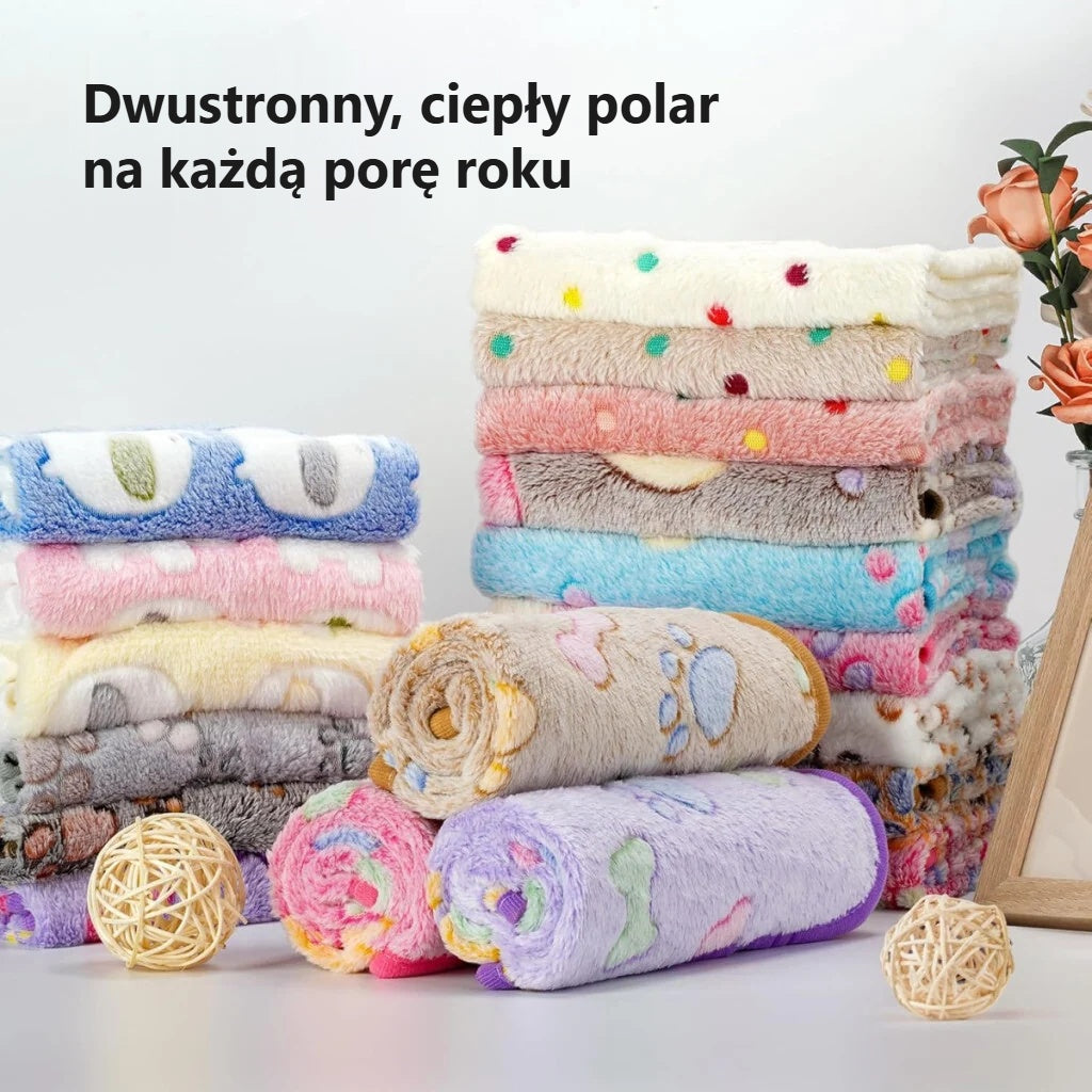 Wzorzyste polarowe kocyki dla zwierząt złożone w stos
