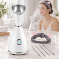 Bílý napařovač obličeje Diozo, vedle žena s čelenkou a nástroje na černé tečky