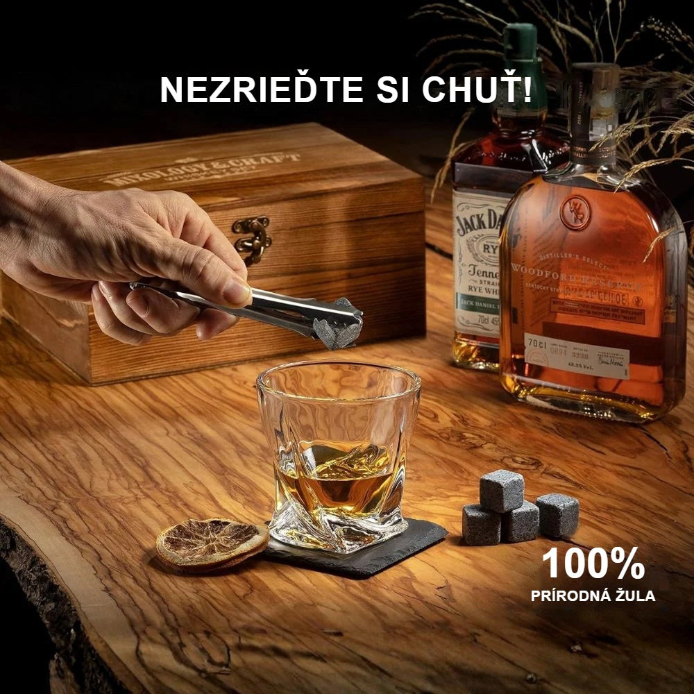 Vkladanie žulového kameňa na whisky do pohára kliešťami na ľad