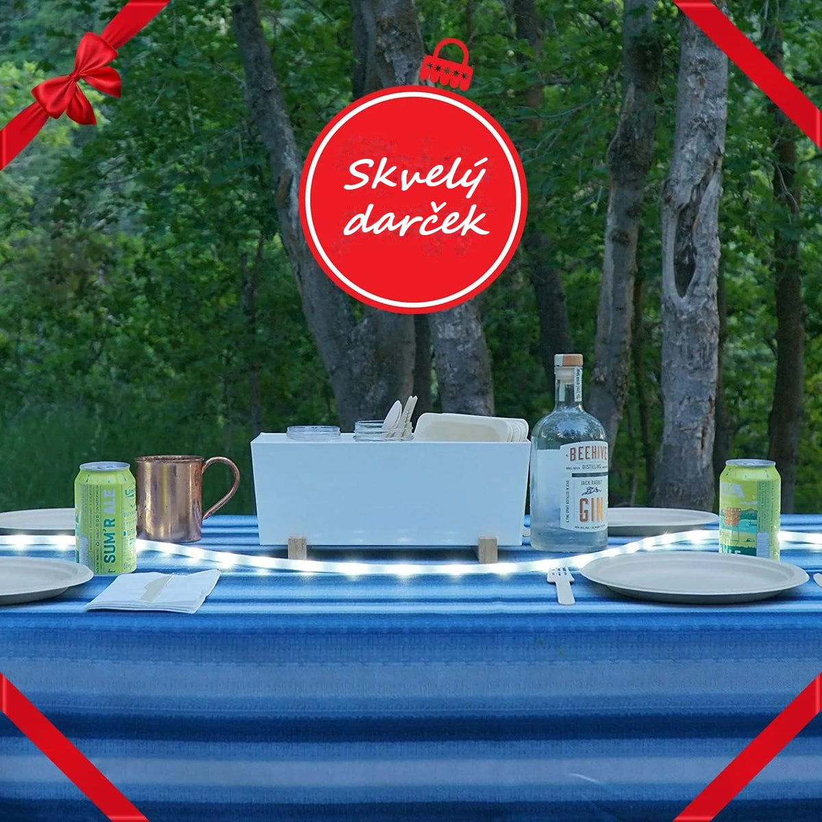 Kempingový stôl medzi stromami osvetlený LED pásikom