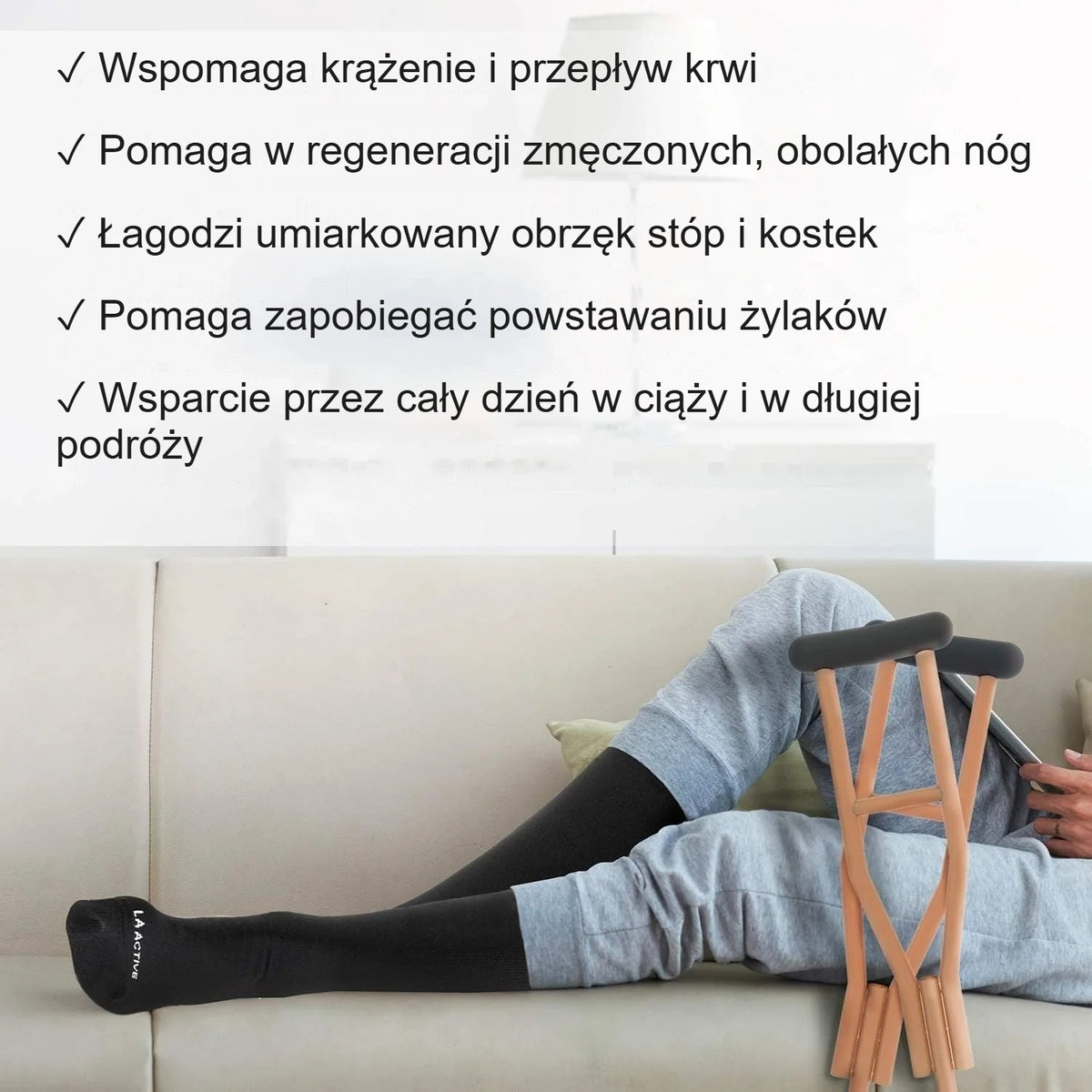 Kobieta rozciąga się na podłodze w czarnych podkolanówkach kompresyjnych