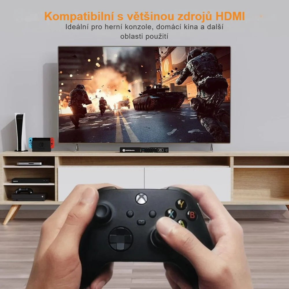 HDMI přepínač s herní konzolí a televizí, ovladač v ruce