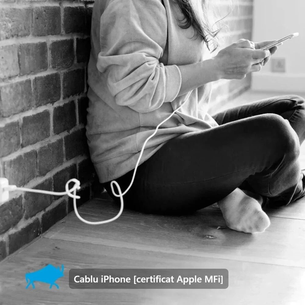 Telefon folosit în timpul încărcării cu cablul pentru iPhone, stând pe podea