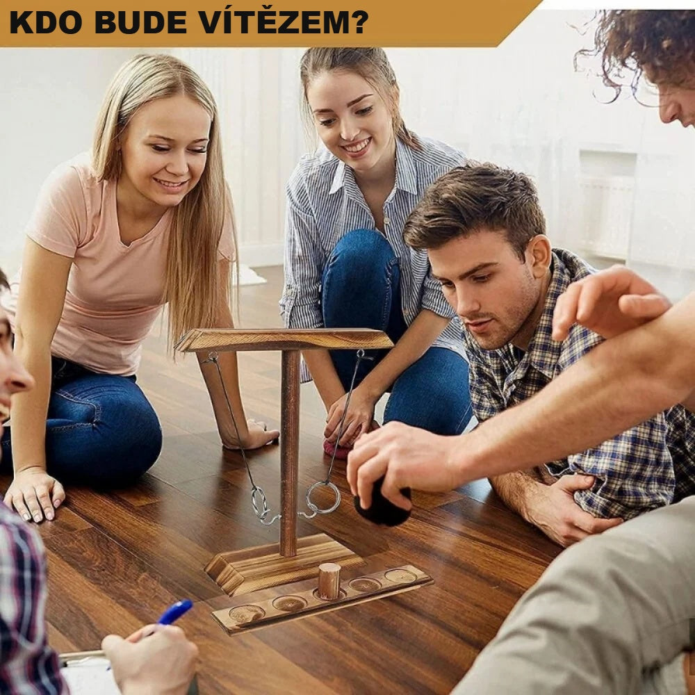 Přátelé hrají hru s házením kroužků u stolu v obývacím pokoji